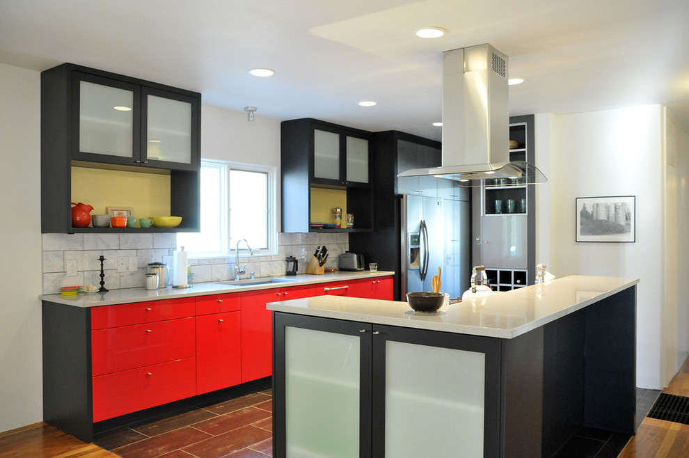 This is an example of a large modern galley kitchen/diner in Albuquerque with a built-in sink, glass-front cabinets, black cabinets, engineered stone countertops, white splashback, stone slab splashback, stainless steel appliances, medium hardwood flooring and an island.