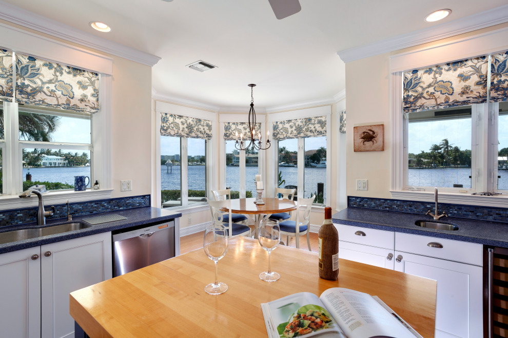 Foto di una cucina costiera di medie dimensioni con lavello sottopiano, ante bianche, paraspruzzi blu, elettrodomestici in acciaio inossidabile, pavimento in legno massello medio e top blu