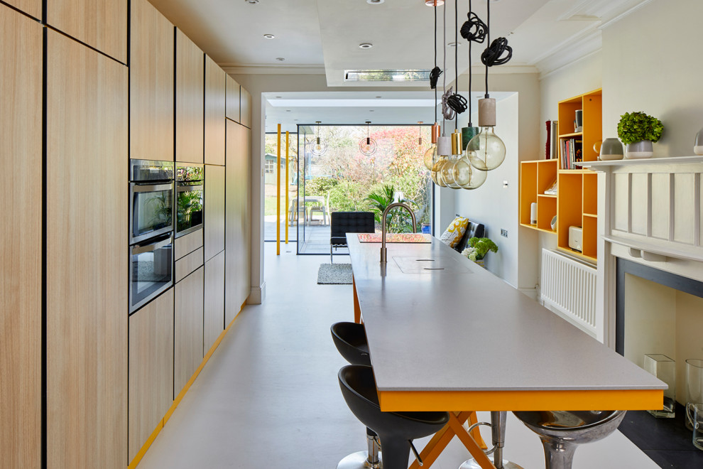 Foto di una cucina contemporanea di medie dimensioni con ante lisce, ante beige, top in superficie solida, elettrodomestici da incasso, pavimento grigio e top grigio
