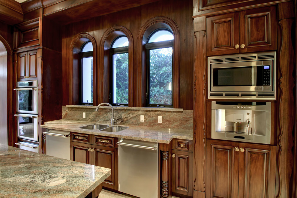 Exempel på ett avskilt, stort klassiskt u-kök, med en dubbel diskho, luckor med infälld panel, skåp i mörkt trä, granitbänkskiva, stänkskydd i sten, rostfria vitvaror, marmorgolv, en köksö och vitt golv