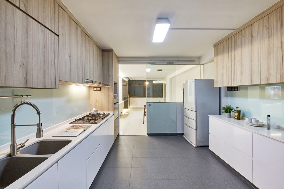 シンガポールにある高級な中くらいな北欧スタイルのおしゃれなキッチン (ダブルシンク、フラットパネル扉のキャビネット、白いキャビネット、御影石カウンター、青いキッチンパネル、ガラス板のキッチンパネル、シルバーの調理設備、セラミックタイルの床) の写真