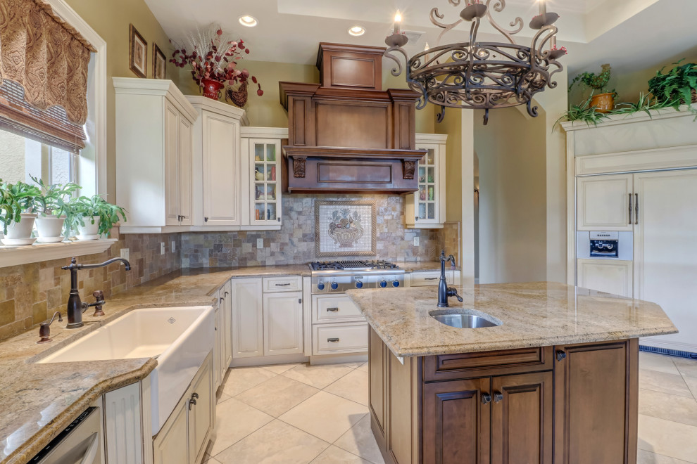 Large elegant l-shaped ceramic tile, beige floor and tray ceiling kitchen pantry photo in Miami with a farmhouse sink, raised-panel cabinets, white cabinets, granite countertops, multicolored backsplash, ceramic backsplash, stainless steel appliances, two islands and multicolored countertops