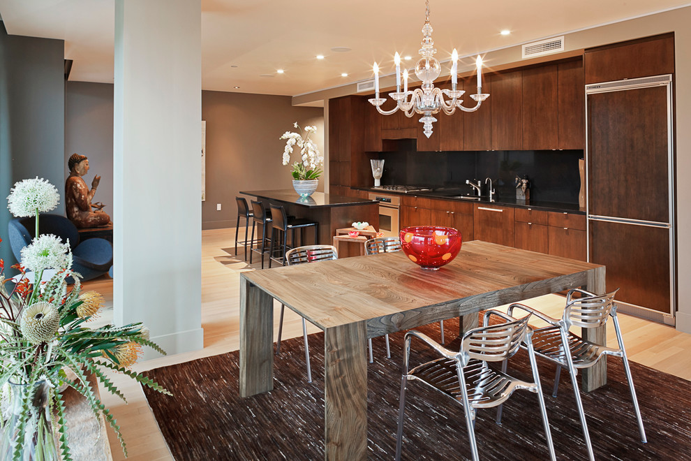 Einzeilige Moderne Wohnküche mit flächenbündigen Schrankfronten, hellbraunen Holzschränken, Küchenrückwand in Schwarz, Glasrückwand und Elektrogeräten mit Frontblende in Portland