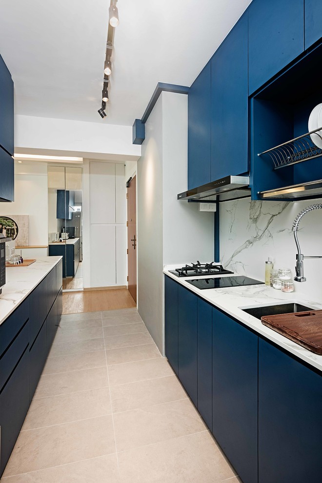 Ispirazione per una cucina parallela minimal con lavello sottopiano, ante lisce, ante blu, elettrodomestici da incasso e pavimento beige