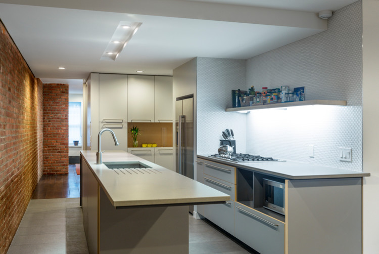 Photo of a small contemporary galley kitchen pantry in New York with a double-bowl sink, flat-panel cabinets, grey cabinets, quartz worktops, white splashback, mosaic tiled splashback, stainless steel appliances, porcelain flooring, an island and grey floors.
