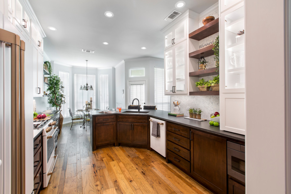 Inspiration for a mid-sized transitional galley medium tone wood floor and brown floor eat-in kitchen remodel in Other with an undermount sink, shaker cabinets, brown cabinets, granite countertops, white backsplash, mosaic tile backsplash, white appliances, no island and black countertops