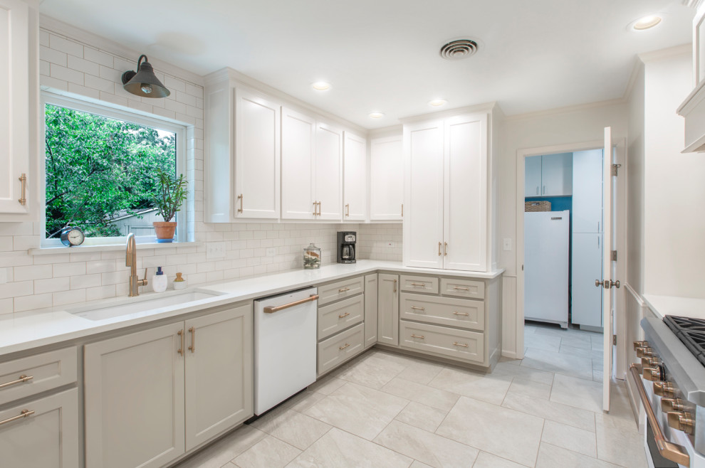 Example of a mid-sized transitional galley ceramic tile and beige floor kitchen design in Other with an undermount sink, flat-panel cabinets, gray cabinets, quartz countertops, white backsplash, subway tile backsplash, white appliances, a peninsula and white countertops