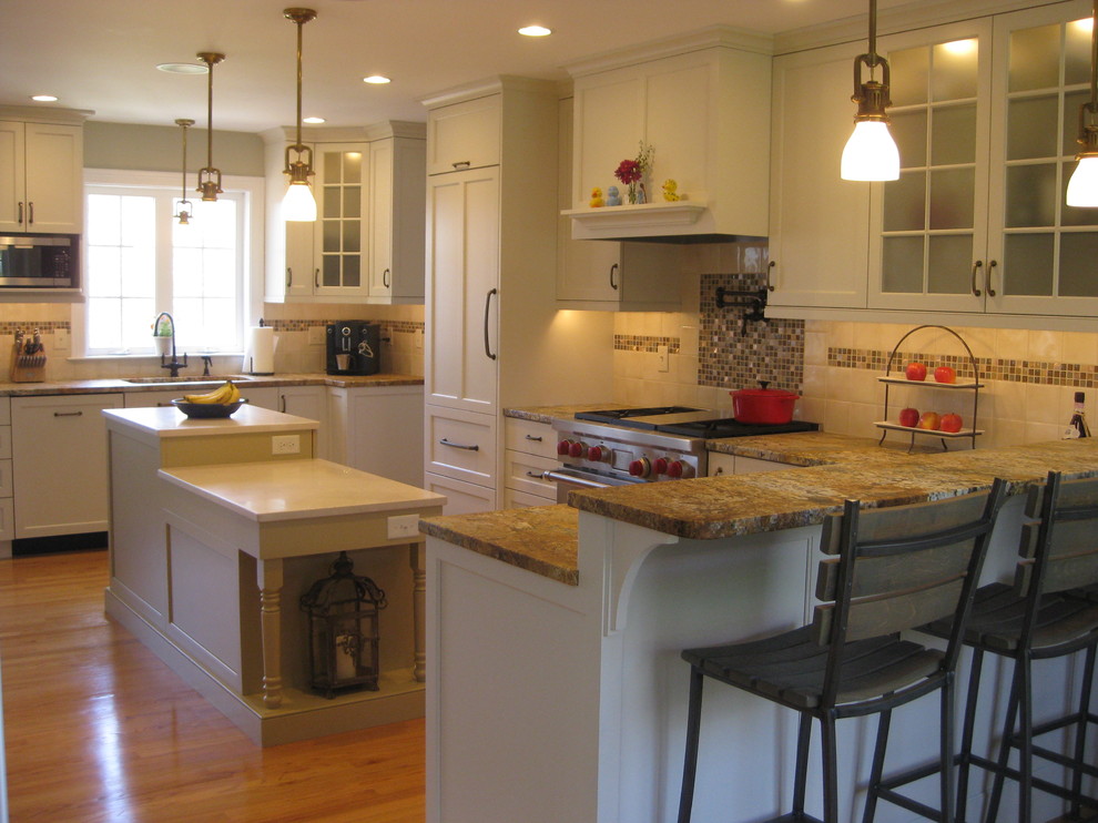 Foto på ett mellanstort vintage kök, med en undermonterad diskho, skåp i shakerstil, vita skåp, granitbänkskiva, vitt stänkskydd, stänkskydd i porslinskakel, rostfria vitvaror, ljust trägolv och en köksö