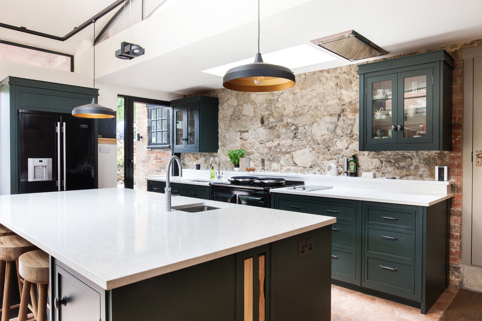 Photo of an expansive farmhouse u-shaped kitchen/diner in Kent with a built-in sink, recessed-panel cabinets, green cabinets, granite worktops, black appliances, terracotta flooring, an island, multi-coloured floors and white worktops.