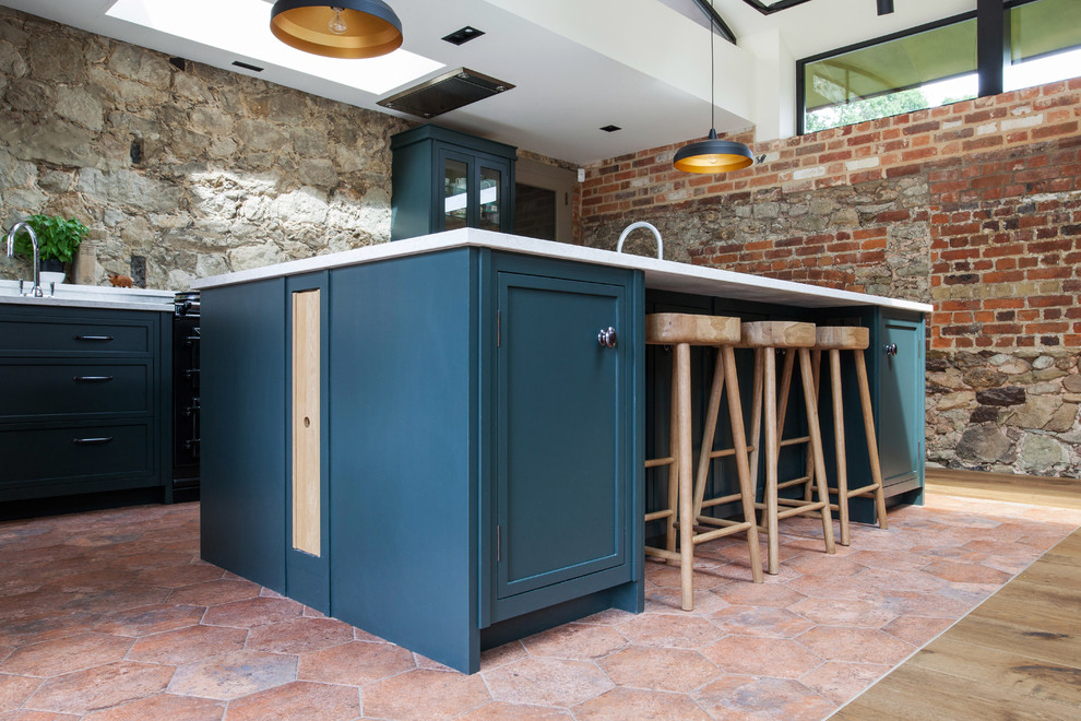 This is an example of an expansive farmhouse u-shaped kitchen/diner in Kent with a built-in sink, recessed-panel cabinets, green cabinets, granite worktops, black appliances, terracotta flooring, an island, multi-coloured floors and yellow worktops.
