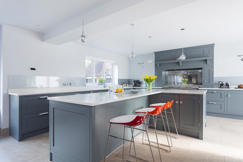 Klassische Küche in L-Form mit Schrankfronten im Shaker-Stil, grauen Schränken, Glasrückwand, Kücheninsel und beigem Boden in Kent