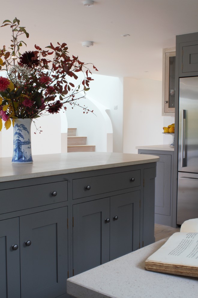 Immagine di una cucina minimal di medie dimensioni con ante in stile shaker, ante grigie, top in marmo, elettrodomestici in acciaio inossidabile e paraspruzzi in marmo