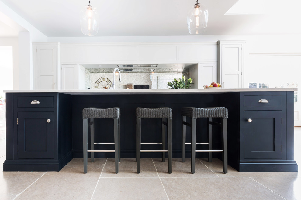 Inspiration for a large timeless galley limestone floor and beige floor open concept kitchen remodel in Kent with an integrated sink, shaker cabinets, gray cabinets, quartzite countertops, metallic backsplash, mirror backsplash, black appliances, an island and white countertops