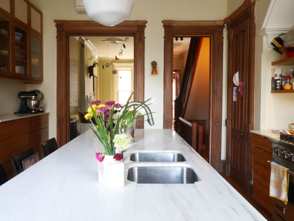 Immagine di una grande cucina vittoriana chiusa con lavello sottopiano, ante di vetro, ante in legno scuro, top in marmo, elettrodomestici in acciaio inossidabile e pavimento in legno massello medio