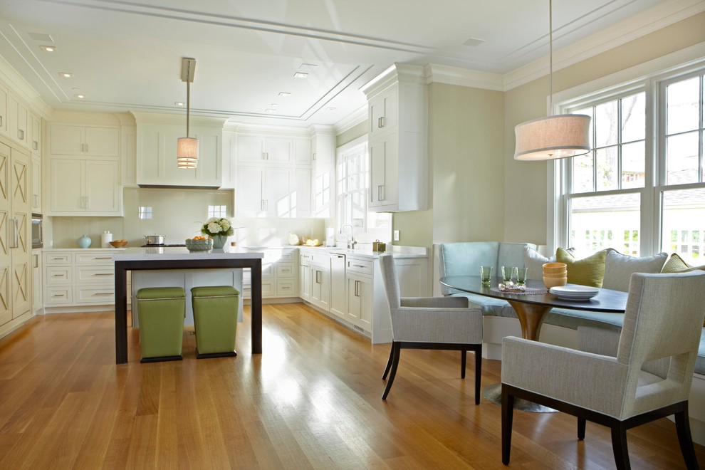 Foto di una cucina classica con ante in stile shaker, ante bianche, paraspruzzi con lastra di vetro e pavimento in legno massello medio
