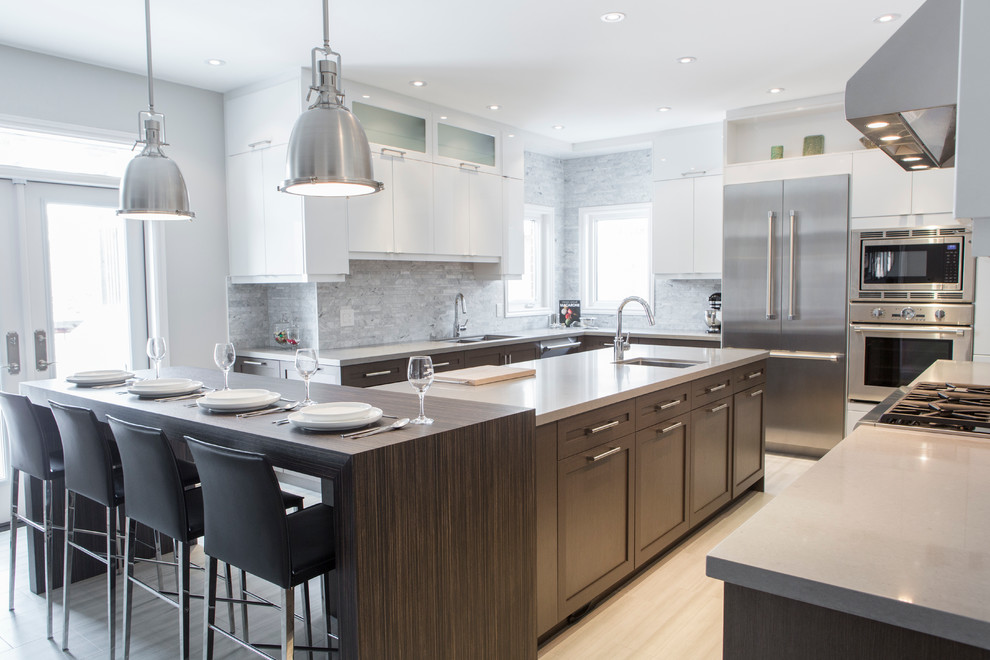 This is an example of a contemporary kitchen in Toronto with a submerged sink, engineered stone countertops, stone tiled splashback and stainless steel appliances.