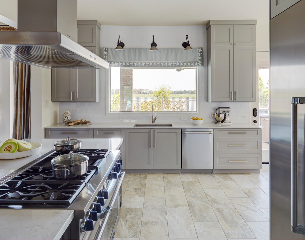 Example of a large transitional u-shaped porcelain tile eat-in kitchen design in Houston with an undermount sink, shaker cabinets, gray cabinets, quartz countertops, white backsplash, porcelain backsplash, stainless steel appliances and an island