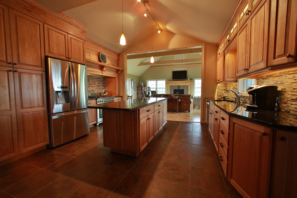 Example of a large transitional galley porcelain tile eat-in kitchen design in Burlington with a double-bowl sink, raised-panel cabinets, light wood cabinets, granite countertops, multicolored backsplash, glass tile backsplash, stainless steel appliances and an island