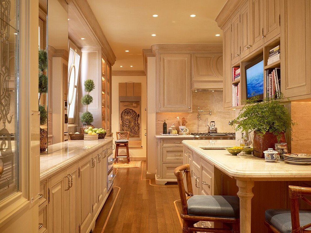 Exempel på ett stort klassiskt kök, med en nedsänkt diskho, luckor med profilerade fronter, beige skåp, bänkskiva i kalksten, beige stänkskydd, stänkskydd i marmor, rostfria vitvaror, ljust trägolv och brunt golv