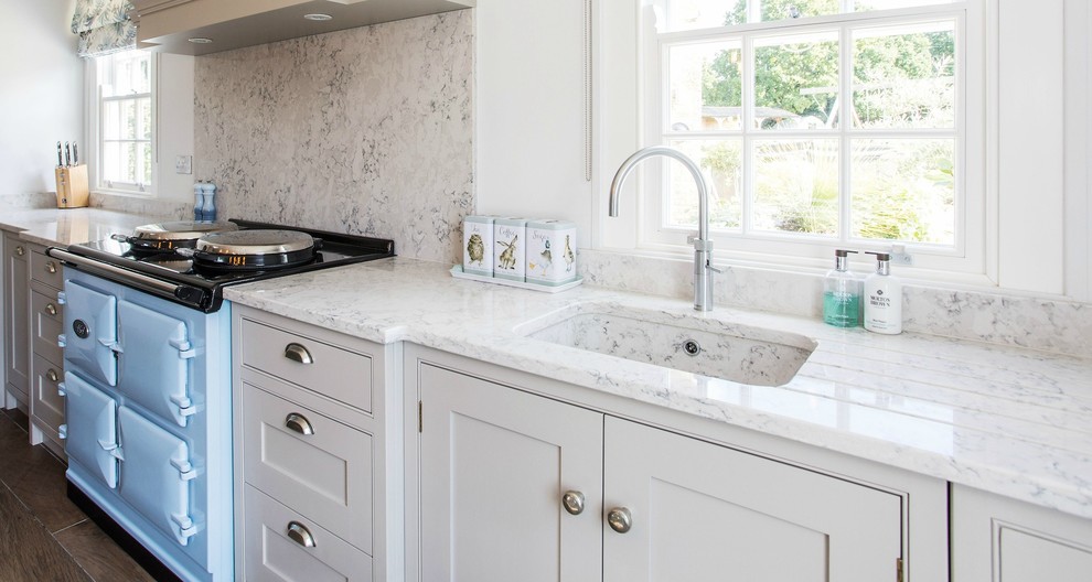 Exempel på ett mellanstort lantligt vit vitt kök, med skåp i shakerstil, grå skåp, bänkskiva i kvartsit, grått stänkskydd, mellanmörkt trägolv, en köksö, en integrerad diskho, stänkskydd i marmor och färgglada vitvaror