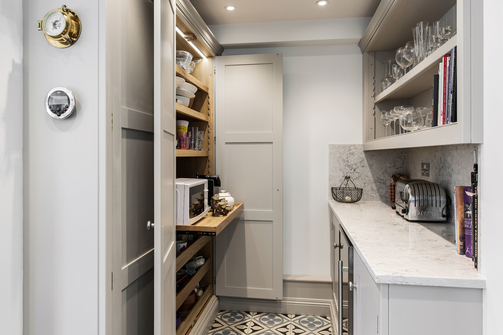 Foto på ett mellanstort lantligt vit kök, med en integrerad diskho, skåp i shakerstil, grå skåp, bänkskiva i kvartsit, grått stänkskydd, stänkskydd i marmor, färgglada vitvaror, mellanmörkt trägolv och en köksö