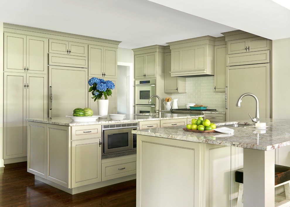 Diseño de cocina clásica de obra con salpicadero de azulejos tipo metro, encimera de granito y electrodomésticos con paneles