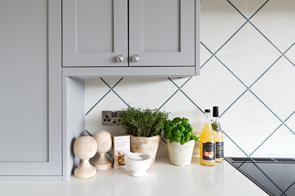 Eat-in kitchen - mid-sized traditional l-shaped porcelain tile and brown floor eat-in kitchen idea in Dublin with a single-bowl sink, shaker cabinets, gray cabinets, quartzite countertops, white backsplash, cement tile backsplash, black appliances, an island and white countertops