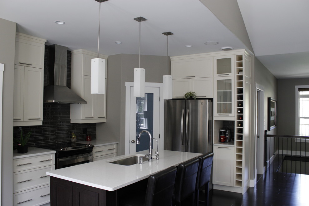 This is an example of a medium sized contemporary l-shaped kitchen pantry in Other with a submerged sink, shaker cabinets, white cabinets, quartz worktops, black splashback, glass tiled splashback, stainless steel appliances, dark hardwood flooring and an island.