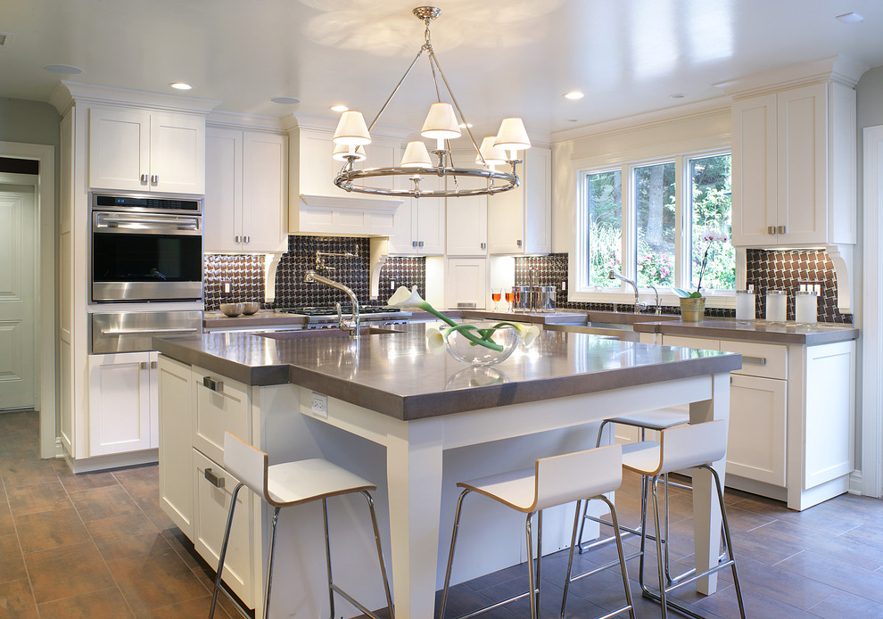 Large contemporary u-shaped kitchen/diner in Las Vegas with stainless steel appliances, concrete worktops, a belfast sink, shaker cabinets, white cabinets, multi-coloured splashback and an island.