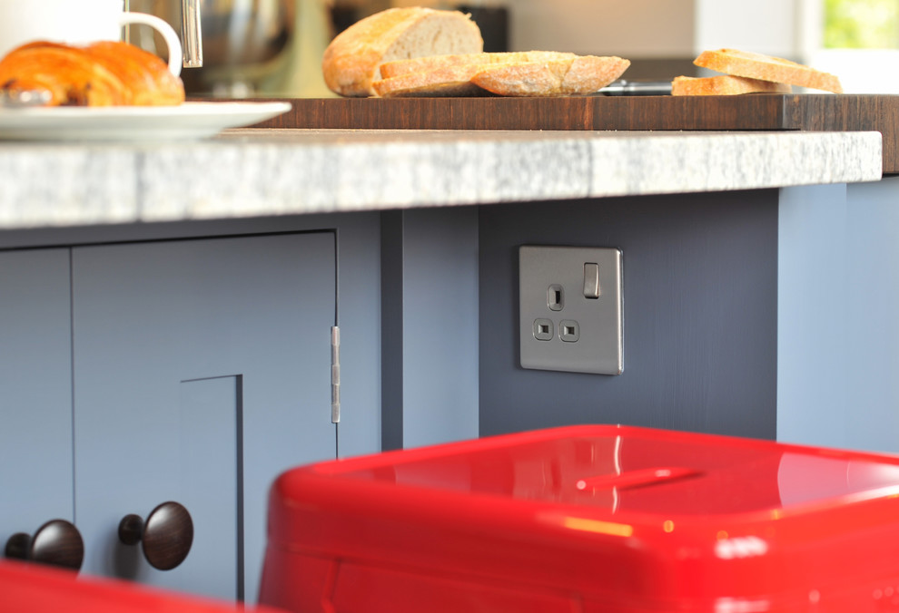 Offene, Große Moderne Küche mit Einbauwaschbecken, blauen Schränken, Granit-Arbeitsplatte, schwarzen Elektrogeräten, Keramikboden und Kücheninsel in Hampshire
