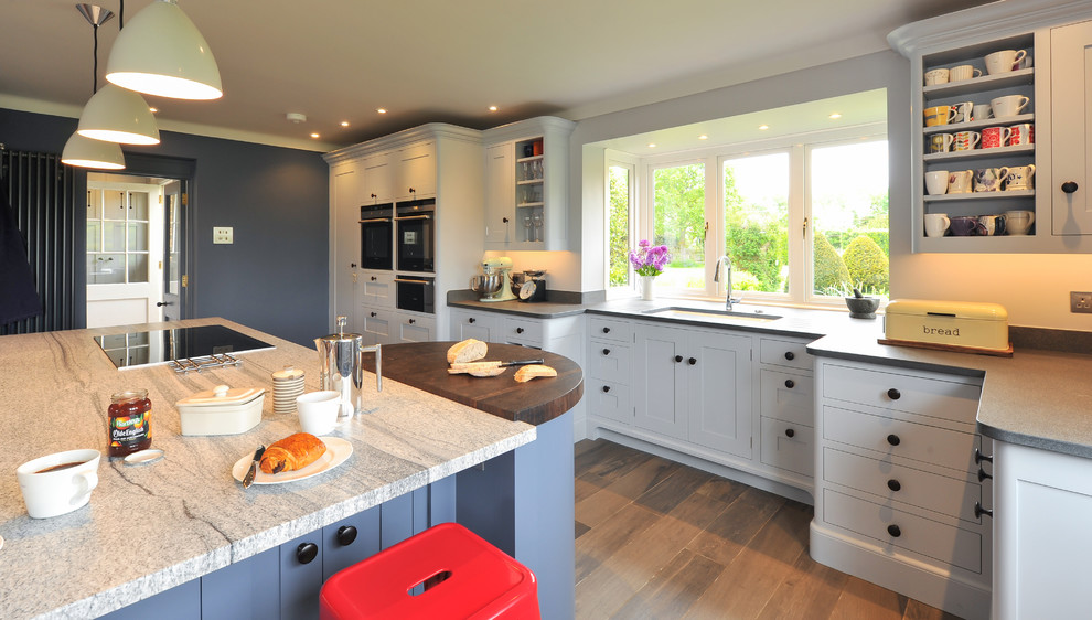Esempio di una grande cucina design con lavello da incasso, ante blu, top in granito, elettrodomestici neri e pavimento con piastrelle in ceramica