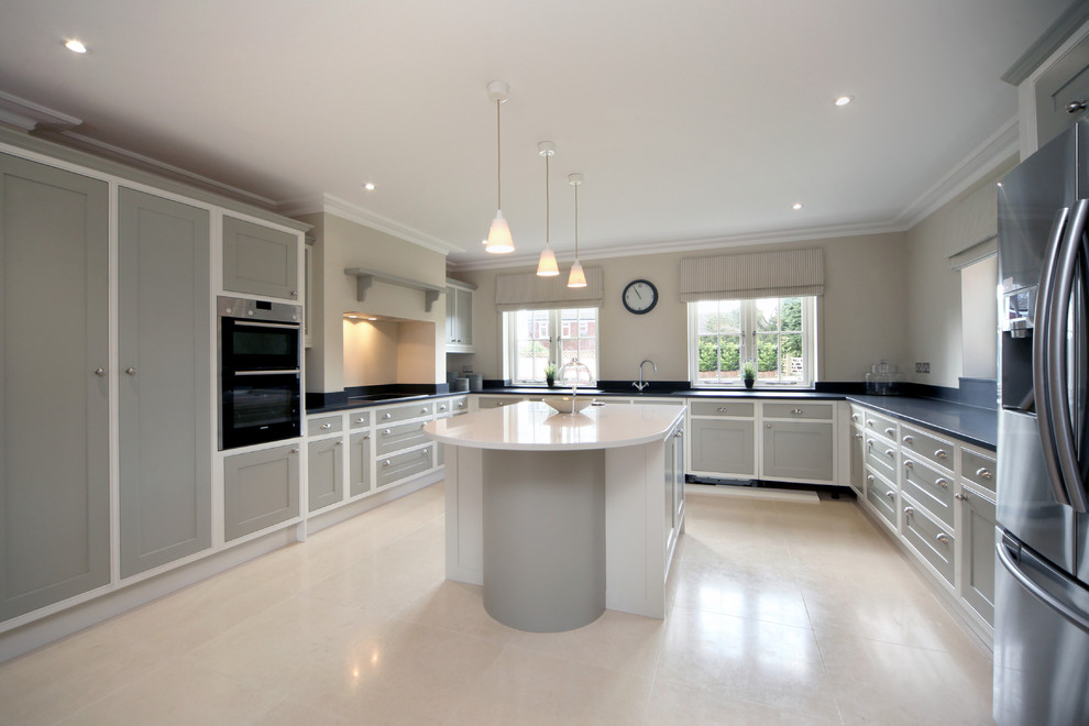 Foto på ett stort lantligt kök, med en integrerad diskho, skåp i shakerstil, grå skåp, granitbänkskiva, integrerade vitvaror, kalkstensgolv och en köksö