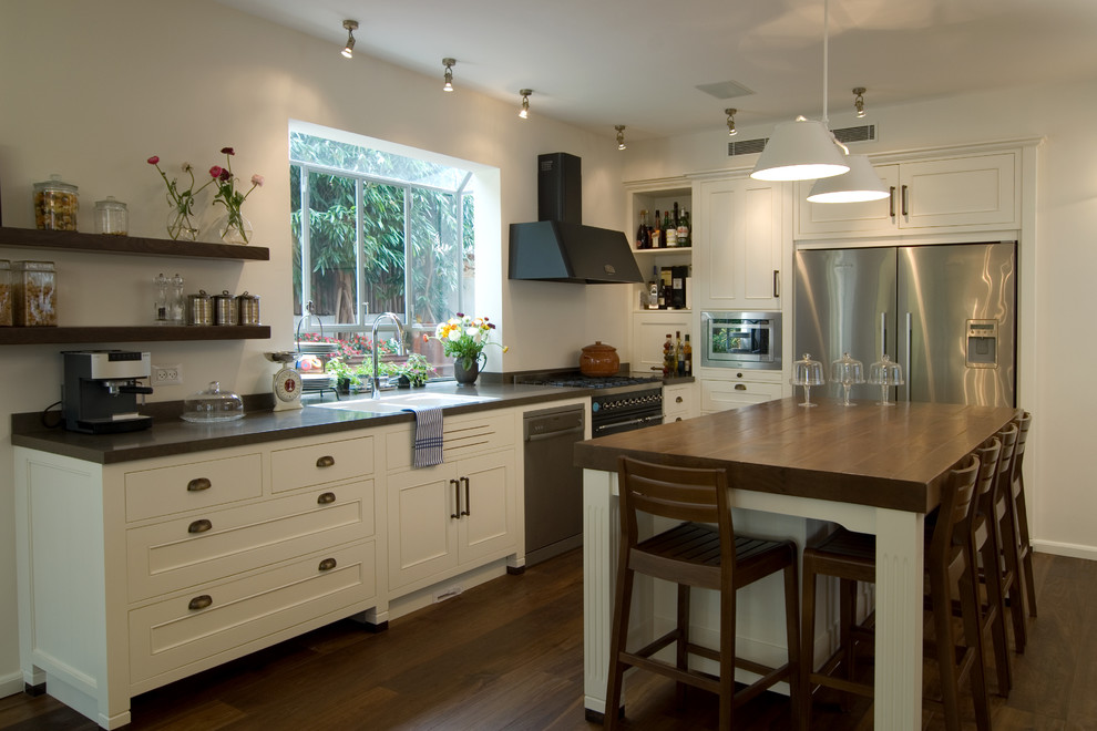 Inspiration for a contemporary l-shaped kitchen remodel in Tel Aviv with stainless steel appliances, a drop-in sink and white cabinets