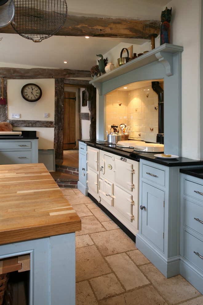 Große Country Küche mit Schrankfronten im Shaker-Stil, blauen Schränken, Granit-Arbeitsplatte, Küchenrückwand in Weiß, beigem Boden und schwarzer Arbeitsplatte in Surrey