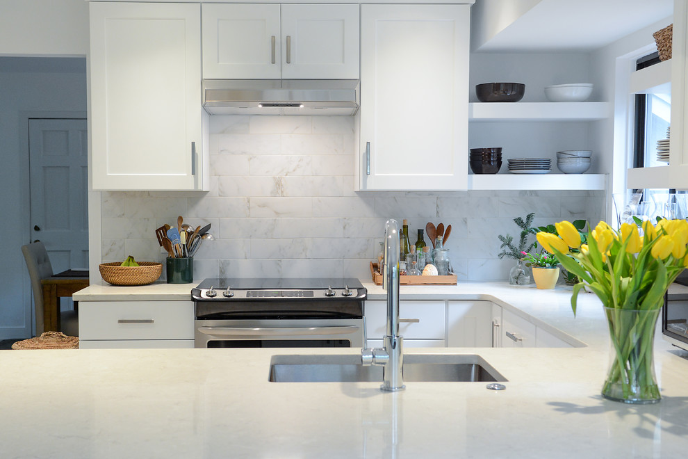 Foto di una cucina ad U minimal con lavello sottopiano, ante in stile shaker, ante bianche e top bianco