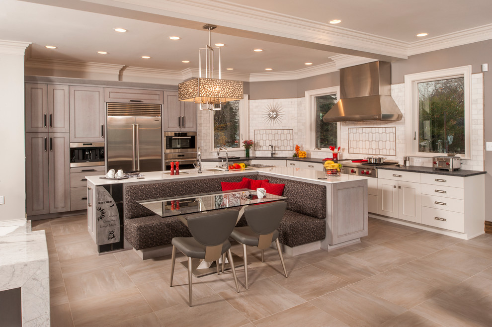 Large traditional l-shaped open plan kitchen in Detroit with a submerged sink, recessed-panel cabinets, white cabinets, engineered stone countertops, white splashback, metro tiled splashback, stainless steel appliances, ceramic flooring and an island.