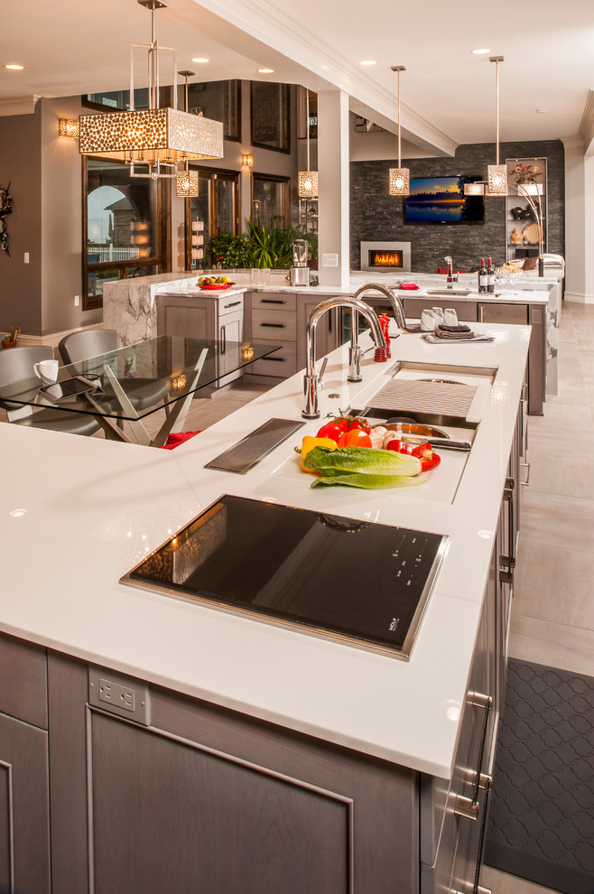 This is an example of a large contemporary l-shaped open plan kitchen in Detroit with a submerged sink, recessed-panel cabinets, white cabinets, engineered stone countertops, white splashback, metro tiled splashback, stainless steel appliances, ceramic flooring and multiple islands.
