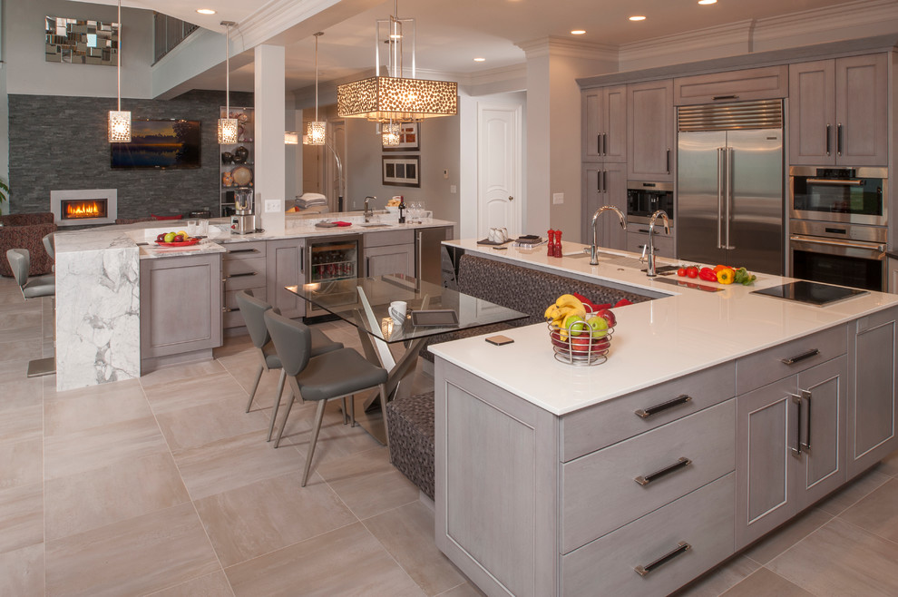 Inspiration for a large transitional l-shaped ceramic tile open concept kitchen remodel in Detroit with an undermount sink, recessed-panel cabinets, white cabinets, quartz countertops, white backsplash, subway tile backsplash, stainless steel appliances and two islands