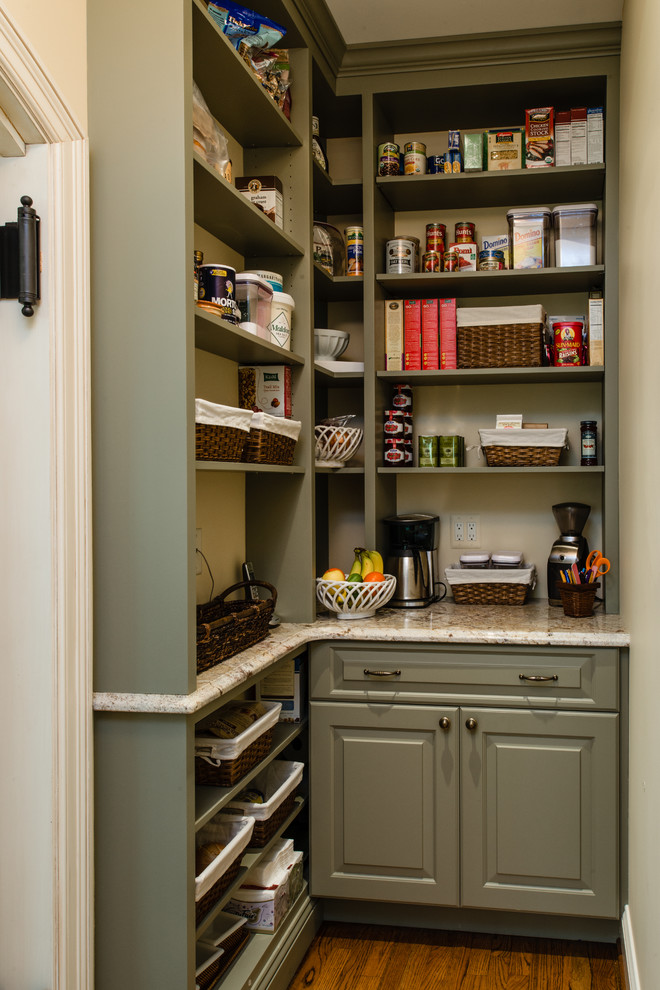 Cette photo montre une arrière-cuisine chic en L avec des portes de placards vertess, un plan de travail en granite et un placard avec porte à panneau surélevé.