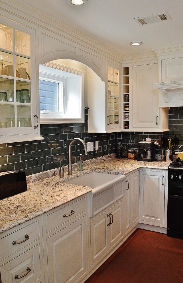 Example of a mid-sized classic l-shaped dark wood floor eat-in kitchen design in DC Metro with a farmhouse sink, raised-panel cabinets, white cabinets, granite countertops, blue backsplash, glass tile backsplash, paneled appliances and an island