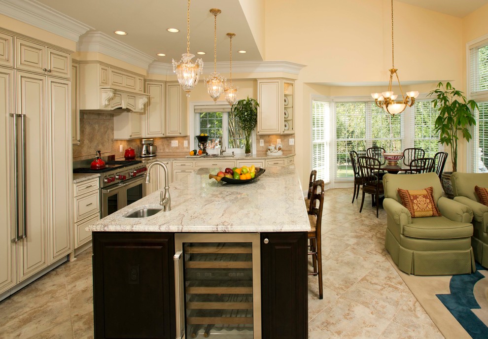 Bild på ett stort lantligt kök, med en undermonterad diskho, luckor med upphöjd panel, beige skåp, marmorbänkskiva, beige stänkskydd, stänkskydd i keramik, rostfria vitvaror, travertin golv, en köksö och beiget golv