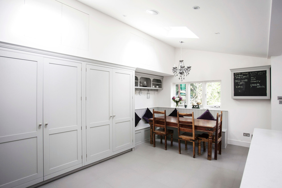 Example of a large trendy u-shaped ceramic tile and white floor eat-in kitchen design in London with a single-bowl sink, shaker cabinets, gray cabinets, granite countertops, white backsplash, ceramic backsplash, paneled appliances, an island and white countertops
