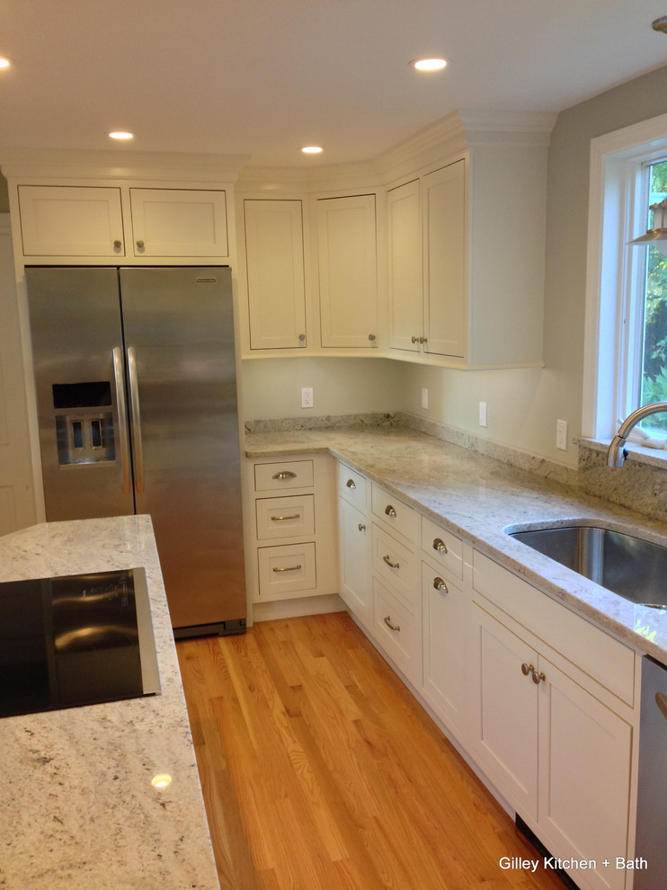 Classic u-shaped kitchen/diner in Bridgeport with a submerged sink, beaded cabinets, white cabinets, granite worktops and stainless steel appliances.