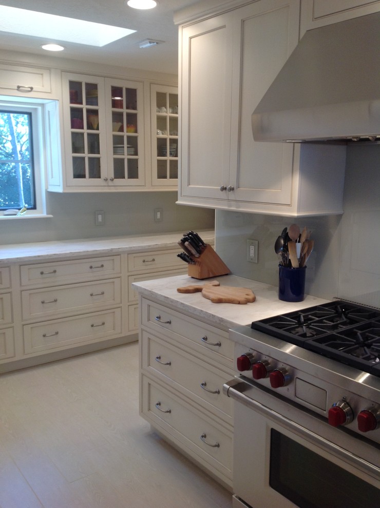 Mid-sized elegant u-shaped travertine floor enclosed kitchen photo in Miami with an undermount sink, shaker cabinets, white cabinets, quartzite countertops, gray backsplash, stone slab backsplash, stainless steel appliances and a peninsula