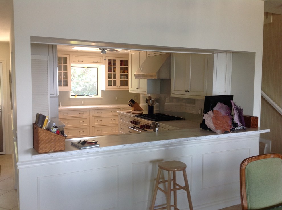 Enclosed kitchen - mid-sized traditional u-shaped travertine floor enclosed kitchen idea in Miami with an undermount sink, shaker cabinets, white cabinets, quartzite countertops, gray backsplash, stone slab backsplash, stainless steel appliances and a peninsula