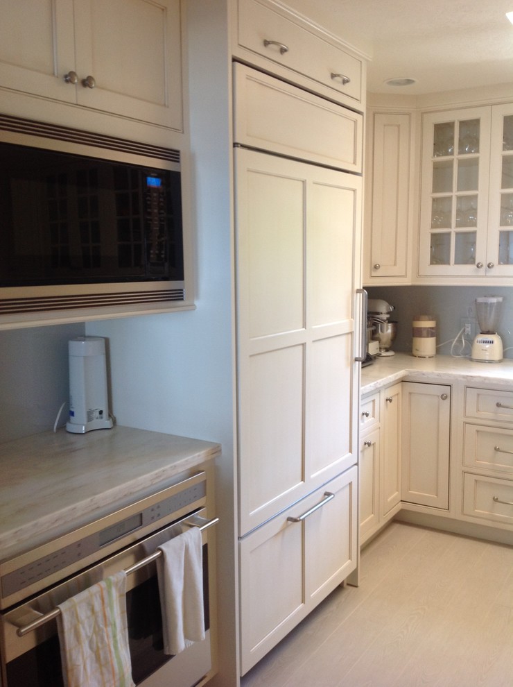 Mid-sized elegant u-shaped travertine floor enclosed kitchen photo in Miami with an undermount sink, shaker cabinets, white cabinets, quartzite countertops, gray backsplash, stone slab backsplash, stainless steel appliances and a peninsula