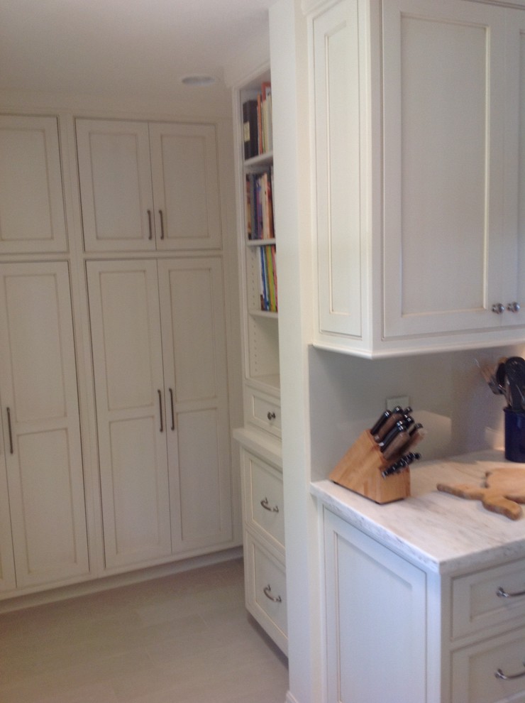 Mid-sized elegant u-shaped travertine floor enclosed kitchen photo in Miami with an undermount sink, shaker cabinets, white cabinets, quartzite countertops, gray backsplash, stone slab backsplash, stainless steel appliances and a peninsula