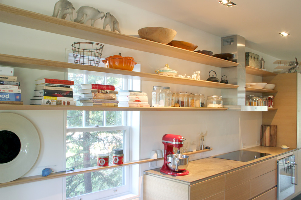 Imagen de cocina minimalista con armarios abiertos, puertas de armario de madera clara y electrodomésticos de acero inoxidable