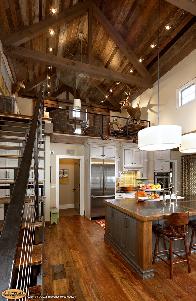 Example of a mountain style eat-in kitchen design in Other with a farmhouse sink, beaded inset cabinets, green cabinets, limestone countertops, yellow backsplash and stainless steel appliances