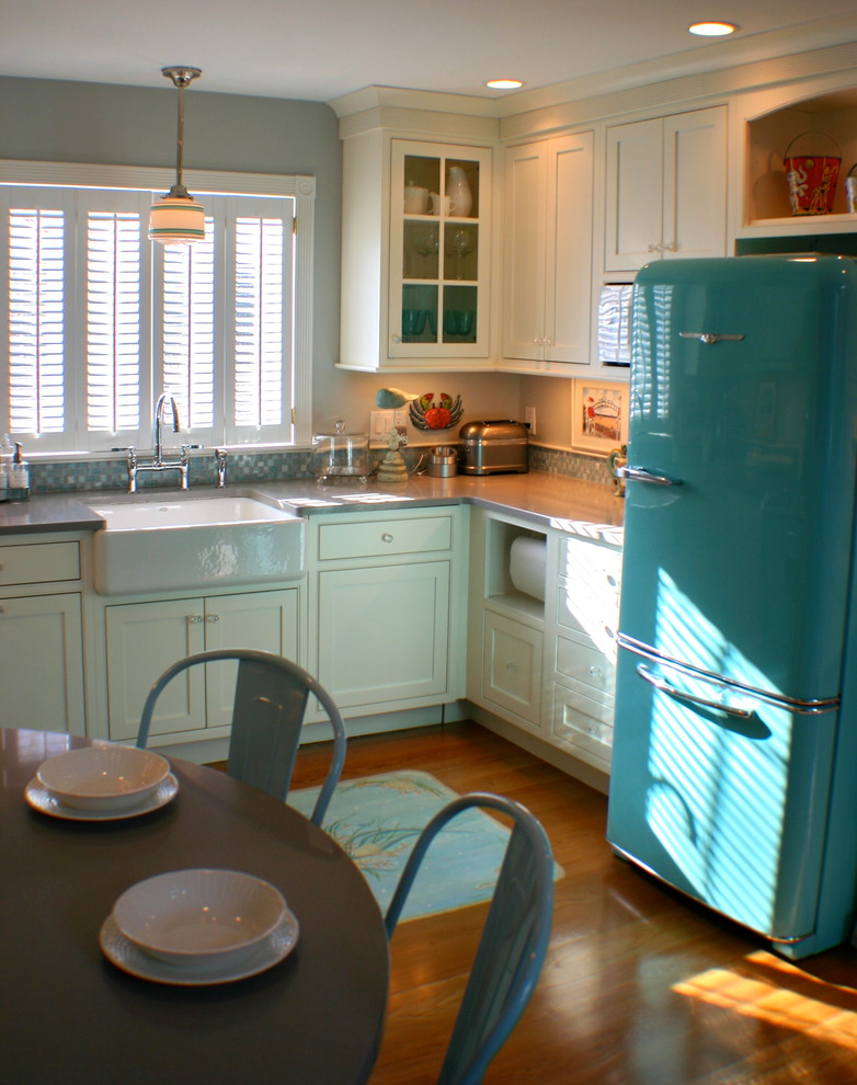Example of a small classic u-shaped medium tone wood floor kitchen design in Boston with a farmhouse sink, beaded inset cabinets, white cabinets, quartz countertops, glass tile backsplash and colored appliances